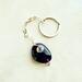 Handmade Amethyst keychain with deep purple stone, silver wire wrap, and infinity loop chain shown on neutral white leather background.